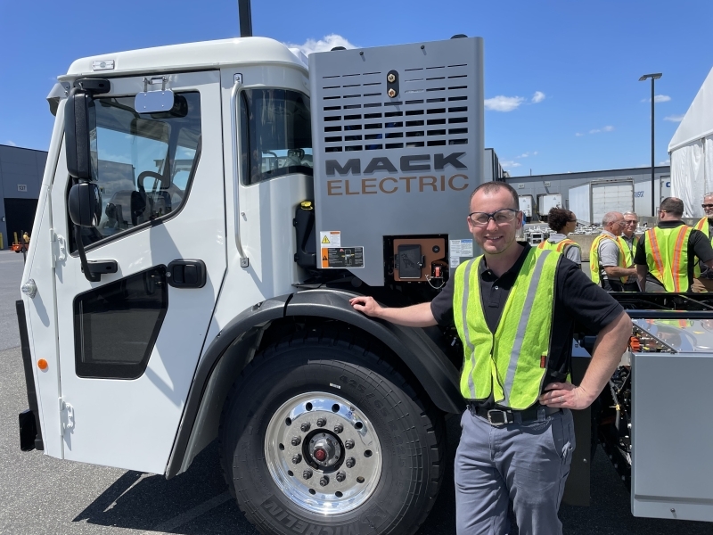 Dan Robb next to an electric mack truck. 