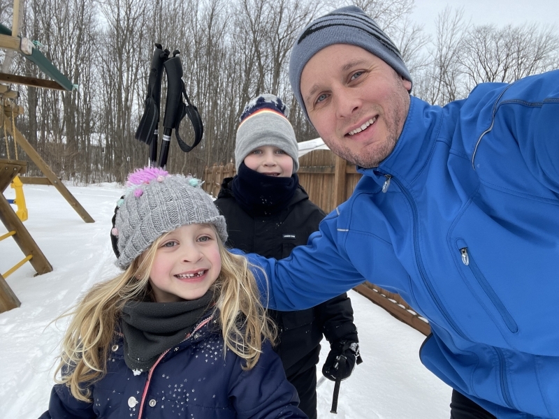 Dan with his two kids playing the snow. 